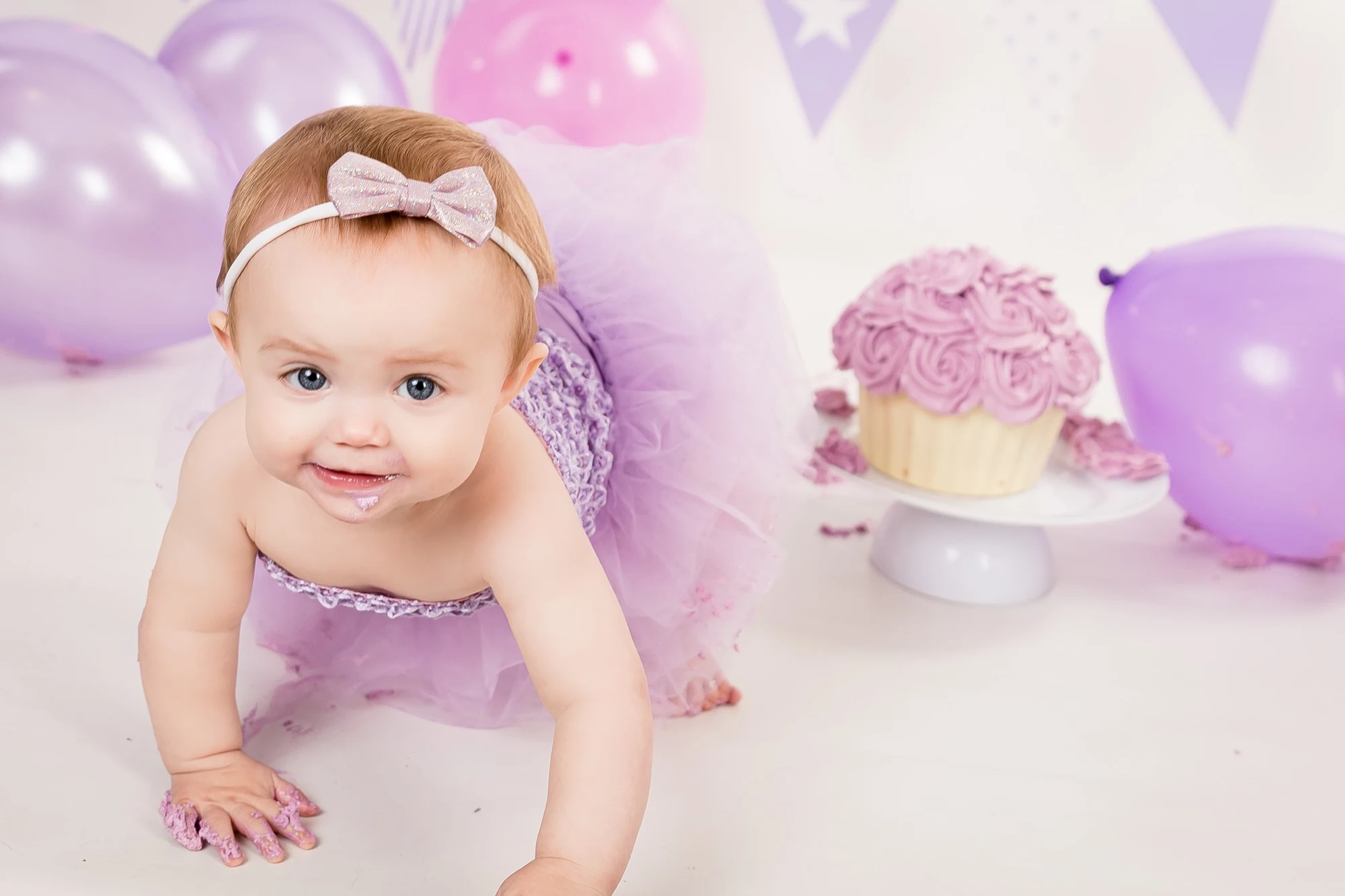 Toddler smiling during a cake-smash session